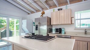 Eine moderne Küche mit einer großen Kochinsel, Edelstahlgeräten und Holzschränken.