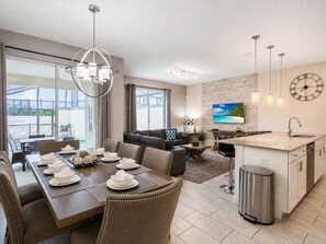 Un salon moderne comprenant un coin repas, une cuisine et un balcon.