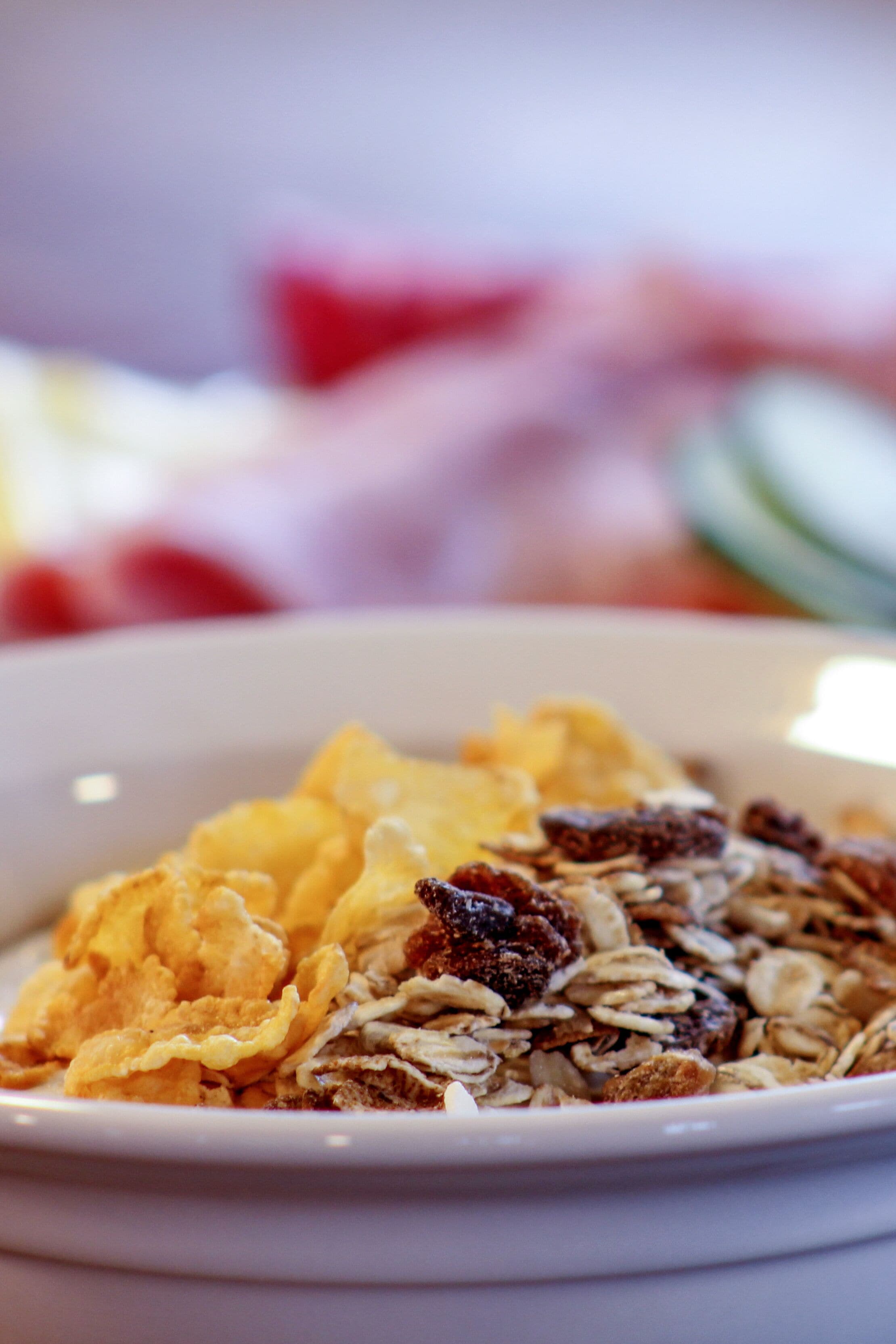 A bowl of cereal with flakes and dried fruits.