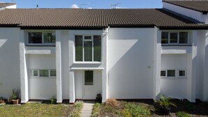 A two-story residential building with a tiled roof, white exterior walls, and a small front garden with potted plants. - Sleeps6- Countryside Privacy- 30mintobeach (Gunnislake)