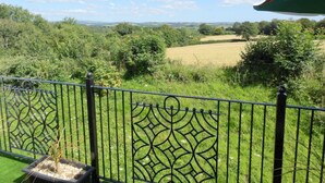 A balcony with a view of a green field and trees under a clear sky. - Sleeps6- Countryside Privacy- 30mintobeach (Gunnislake)