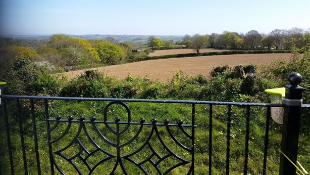 A view from a balcony with a metal railing, overlooking a rural landscape with fields and trees. - Sleeps6- Countryside Privacy- 30mintobeach (Gunnislake)