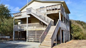 A two-story building with a balcony and a staircase leading to the upper floor. - Charming, well maintained contemporary home with every attention to detail. (Duck)