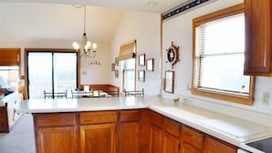 A kitchen with wooden cabinets, a large island, and a window. - Charming, well maintained contemporary home with every attention to detail. (Duck)