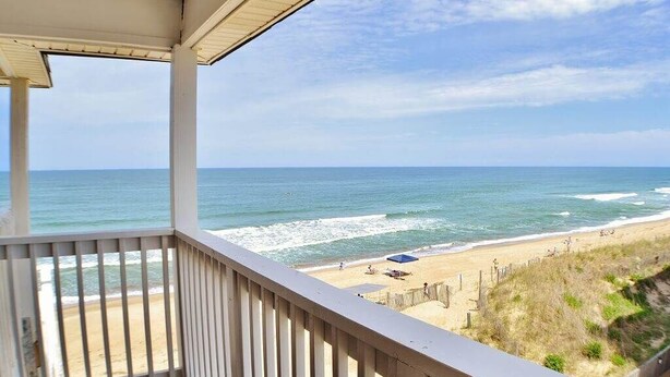 A balcony with a view of the beach and ocean. - Oceanfront Condo on the Outer Banks (Kill Devil Hills)