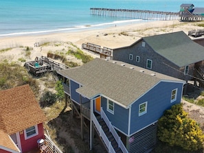 A coastal house with a beach view, a pier, and a small dock. - Charming Oceanfront retreat (Kill Devil Hills)