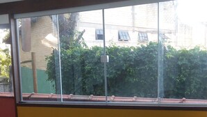 Una habitación con un ventanal grande, un sofá y una mesa.