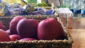 A basket of red apples on a table with snacks and bottled water. - Fortune Hotel Huddersfield M62 JCT24, Sure Collection by Best Western (Huddersfield)