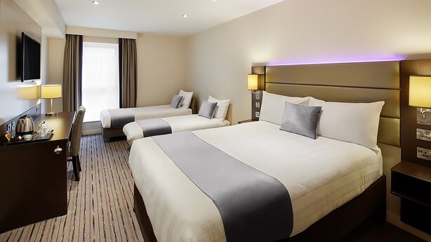 A hotel room with two beds, a desk with a lamp, a TV, and a window with curtains. - Fortune Hotel Huddersfield M62 JCT24, Sure Collection by Best Western (Huddersfield)