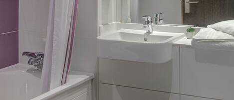 A modern bathroom with a bathtub, sink, and toilet.