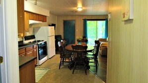 A compact kitchen with wooden cabinets, a stove, and a refrigerator. - Lakefront, Jet ski, kayak,or pontoon rentals. Right on the beach!!! (Murray)