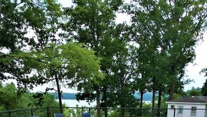 A swimming pool with a curved edge, surrounded by a concrete deck. There are four blue lounge chairs and a small table. - Lakefront, Jet ski, kayak,or pontoon rentals. Right on the beach!!! (Murray)