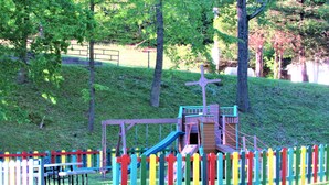 A playground with a slide and climbing structures, surrounded by a colorful fence. - Lakefront, Jet ski, kayak,or pontoon rentals. Right on the beach!!! (Murray)