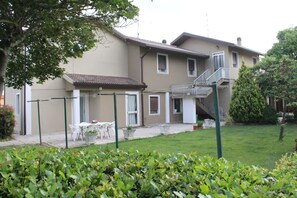 Edifici residencial amb zona de pati, mobiliari exterior i escala que condueix a un pis superior.