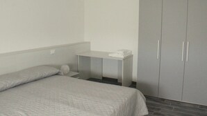 Un dormitorio con cama, mesita de noche y armario.