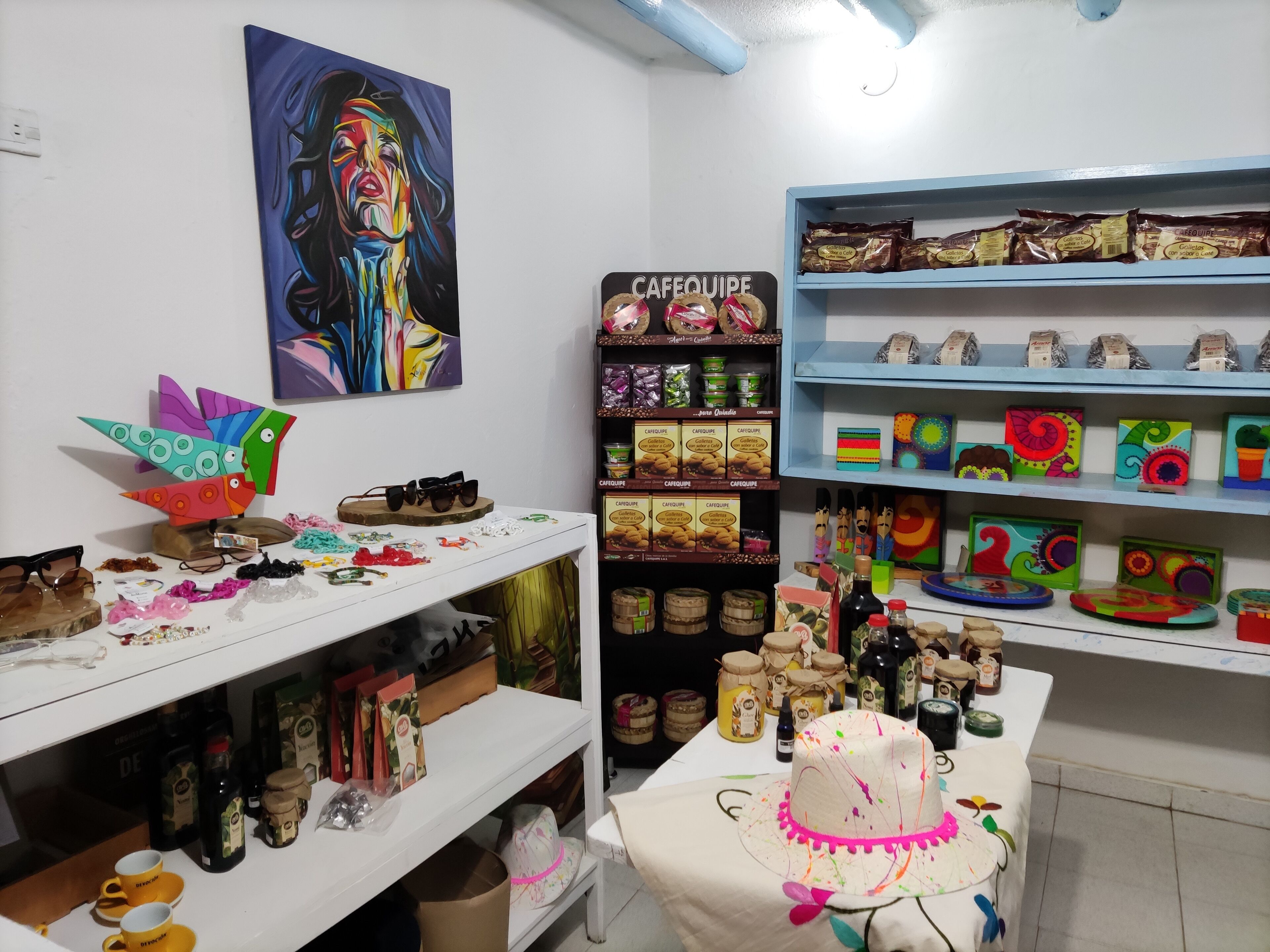 A room with shelves stocked with snacks, a table with a cake, and various items on a counter.