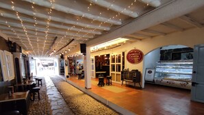 Um café acolhedor, com piso de pedra, luzes de Natal e uma TV antiga.