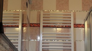 A bathroom with a sink, a mirror, and a shower area. - Camera MINERVA (Pisa)
