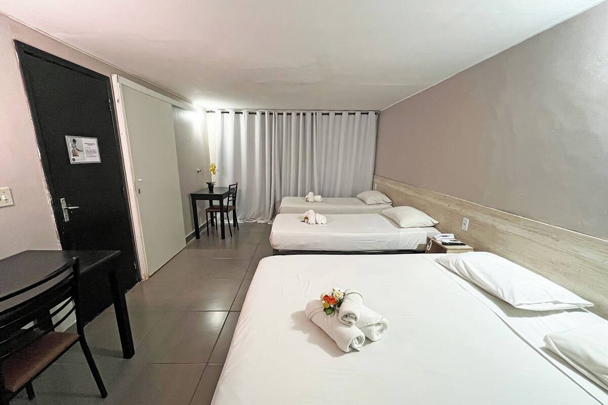 Ein Hotelzimmer mit zwei Betten, einem Schreibtisch und einem Stuhl.