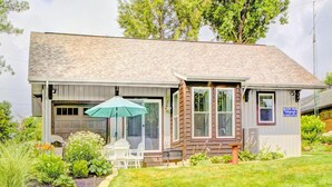 Ein Bungalow mit Veranda, überdachter Terrasse und kleinem Garten.