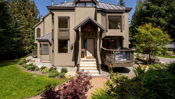 A two-story house with a front porch, a covered deck, and a well-maintained garden. - Prime Central Location | 5BR | Walk to Village/Lifts | Free Parking | Managed by Aloha Whistler (Whistler)