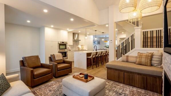 A spacious living area with a sofa, a coffee table, and a kitchen in the background.