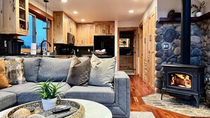 Ein modernes Wohnzimmer mit grauem Sofa, einem Couchtisch und einem Steinkamin.