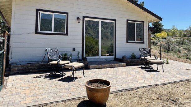 A single-story house with a covered patio area, two windows, and a sliding glass door.