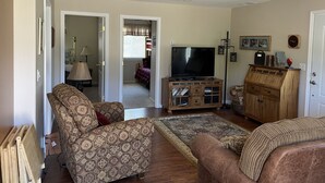 A living room with a patterned sofa, a television, and a wooden cabinet.