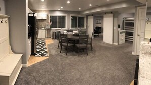 A home interior with a dining area, kitchen, and storage space. - Family Favorite with Indoor Basketball Court (Sandy)