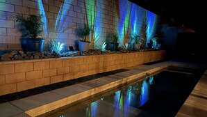 A pool area with a brick wall and potted plants. - Desert Oasis salt water Pool/spaHome, Gated Community w/LAKE (Indio)