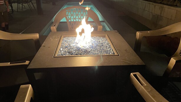 A square table with a glass top and a fire burning in the center. - Desert Oasis salt water Pool/spaHome, Gated Community w/LAKE (Indio)