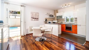 A modern kitchen with white cabinets, an orange countertop, and a built-in oven. - Lorena Suite - Two Bedroom Apartment with Private Pool (Dubrovnik)
