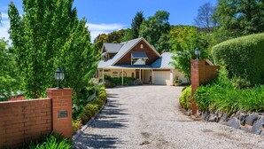 A two-story house with a gravel driveway leading to a garage. - Greenlea (BRIGHT)