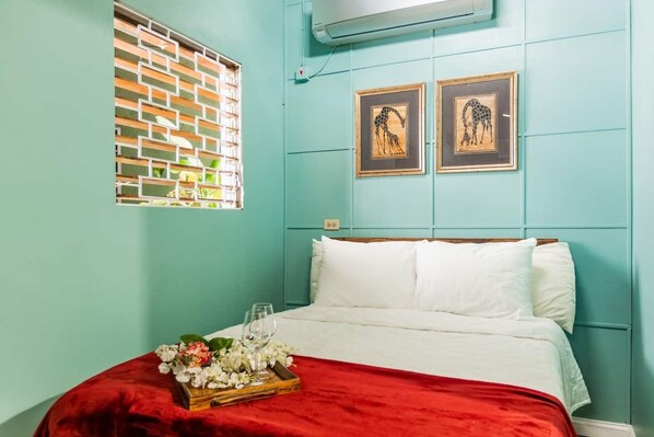 A room with a bed, a window with a brick pattern, and two framed pictures on the wall. - Close to great food & essentials (Kingston)