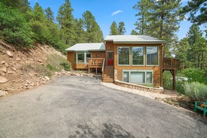 A cabin with a porch, a covered deck, and a stone foundation. - Beautiful Rustic Mountain Home (Durango)