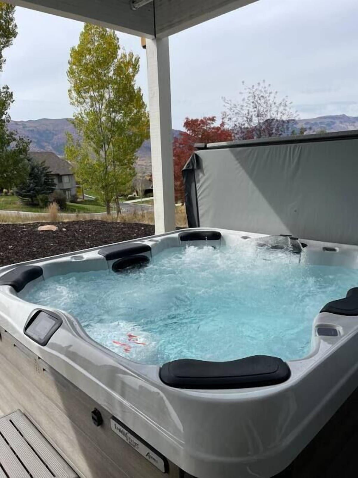 A hot tub with a view of a mountain landscape.