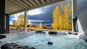 A hot tub with a view of autumn trees and a cloudy sky. - The Ledges | Ski Getaway | Hot Tub & Theater Room (Eden)