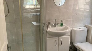 A bathroom with a glass-enclosed shower, a sink with a mirror, and a toilet. - Professional Bed & Breakfast en-suite double rooms £80 per night per room. (Warwick)