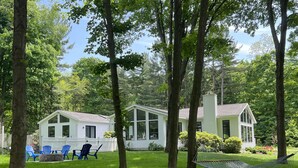 A house with a white exterior, a covered porch, and a hammock in the yard. - Ultimate Family Retreat: Pool, Huge Yard, Gardens, Chickens, 5 Beaches Closeby (Fennville)