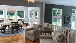 A dining area with a round table, chairs, and a chandelier. - Ultimate Family Retreat: Pool, Huge Yard, Gardens, Chickens, 5 Beaches Closeby (Fennville)