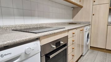 Een keuken met een vaatwasser, oven en wasmachine.