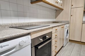 Una cocina equipada con lavavajillas, horno y lavadora.