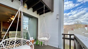 A wooden deck with two white wicker chairs and a hanging chair. - SunBear- AC, Pool, Game Room, Fireplace, Hiking! (Killington)