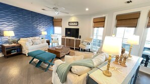 A living room with a blue textured wall, a sofa, a coffee table, and a TV.