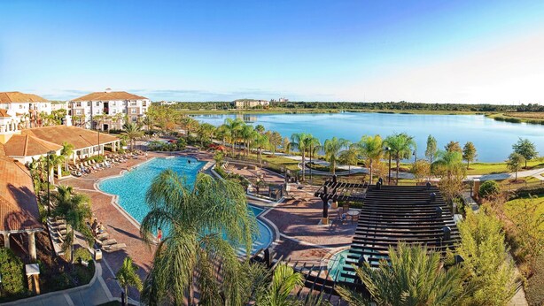 Ein Resort mit großem Schwimmbad, Tennisplatz und Seeblick.