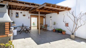 A patio with a wooden pergola, outdoor seating, and potted plants. - Apartment Blue, Casa El Patio (Adults Only) (Teguise (Lanzarote))