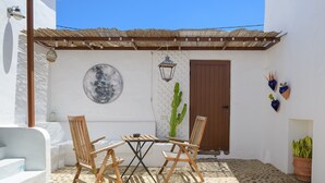 An outdoor patio with a wooden table and chairs, a cactus, and a door. - Apartment Green, Casa El Patio (Only Adults) (Teguise (Lanzarote))