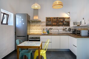 A compact kitchen with a refrigerator, a microwave, a sink, and a dining area with two chairs. - Apartment Green, Casa El Patio (Only Adults) (Teguise (Lanzarote))