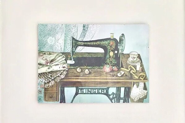 A vintage Singer sewing machine on a wooden table with lace and fabric items.